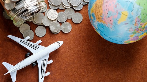 Coins, globe, and airplane model symbolizing travel and cross-border finances
