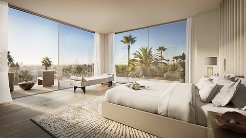 Primary bedroom with floor-to-ceiling windows overlooking palm trees and Beverly Hills skyline