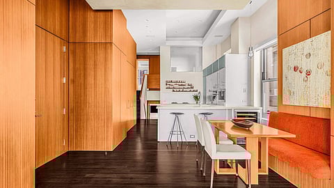 Open loft kitchen and dining space with wood walls, white island, and built-in seating