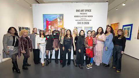 Group of women artists posing at One Art Space gallery during She Is 2026 exhibition