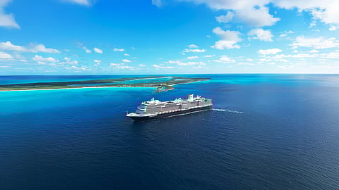 Cruise ship sailing through blue waters under a bright blue sky