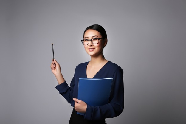 Woman holding notebook and pen representing nonverbal communication and doula support training