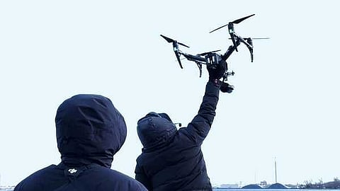 Person launching a drone over water to capture aerial data and site insights