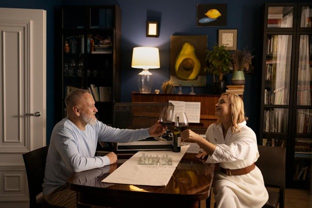 Couple toasting wine at a dining table in a warmly lit home interior