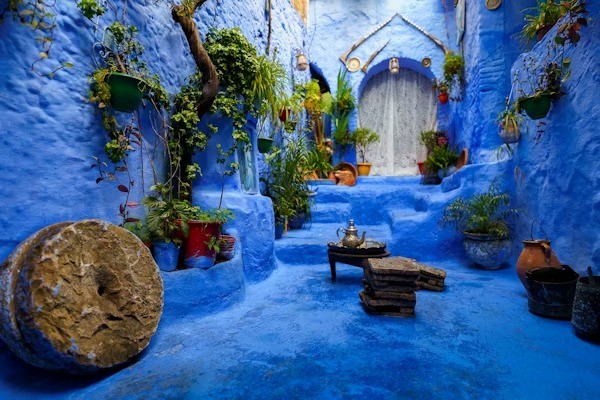 Blue-painted courtyard with plants and traditional decor in Moroccan village