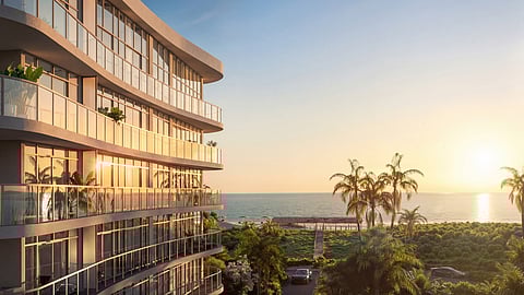 Oceanfront building at sunset with palm trees and beach view