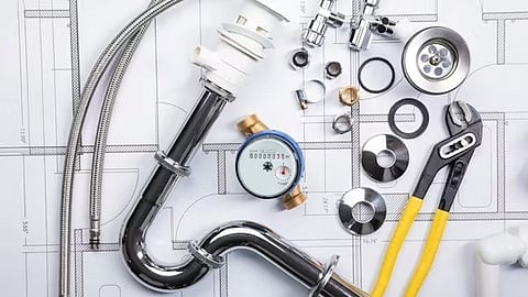 Plumbing pipes, tools, and fittings on blueprint representing home maintenance and infrastructure