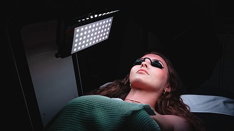 Client receiving LED light therapy treatment in a modern medical spa setting