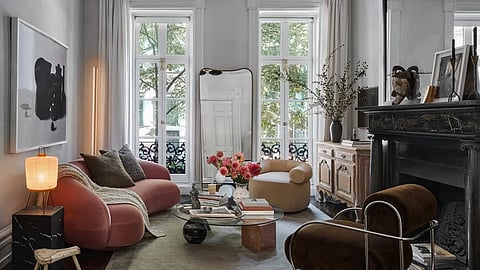 Living room with curved sofa, fireplace, and curated art-filled interior