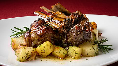 Roasted lamb with potatoes and rosemary on white plate