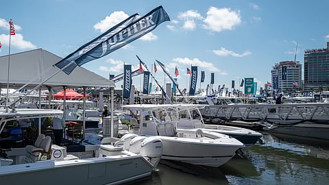 Boats docked at marina with Jupiter flags and crowds walking along docks