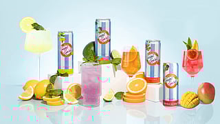 Assorted Saint Spritz cans and cocktails with citrus and tropical fruit