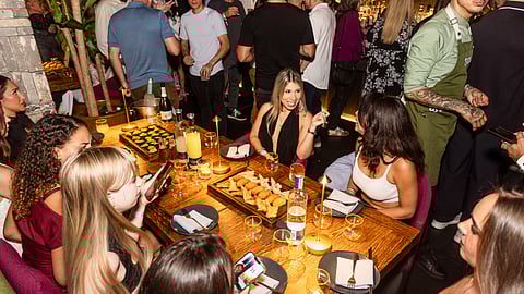 Group of guests dining and socializing at restaurant event table in Miami