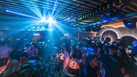 Crowded dance floor at MILA Lounge with disco ball lighting and live performance atmosphere