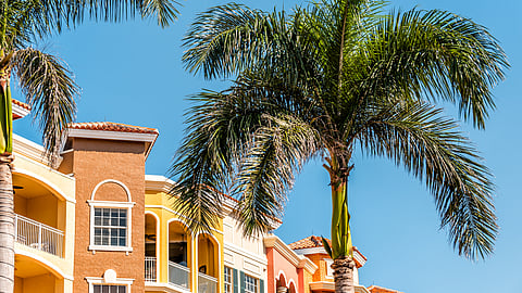 Condominiums, multicolored orange, yellow, colorful tropical, with palm trees in Florida