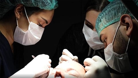 Medical team performing a hair transplant procedure with surgical precision