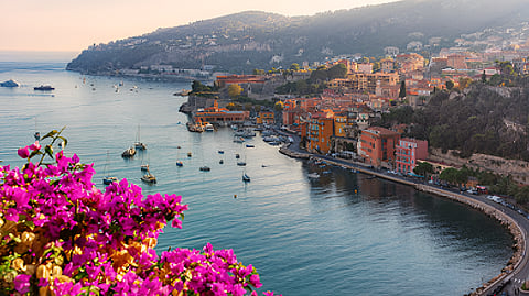 Coastal town with boats and hillside homes along Mediterranean shoreline