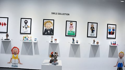Gallery wall with framed character portraits and sculptural works on display