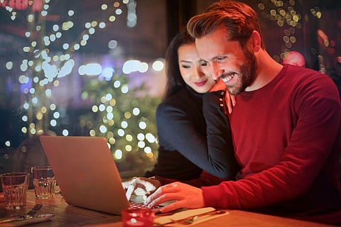 A couple looking at a laptop together in a cozy setting