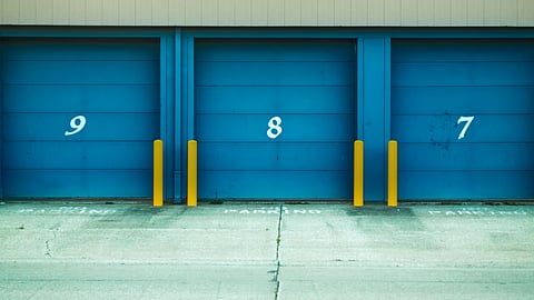 Blue storage unit doors labeled with numbers in a clean, minimalist facility setting