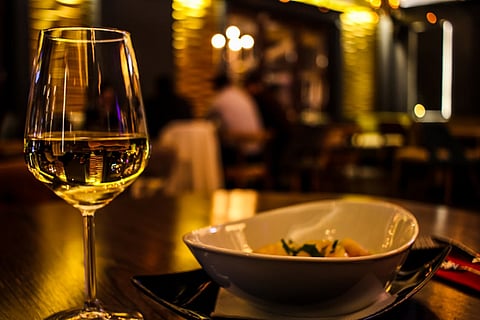 A glass of white wine placed on a wooden table