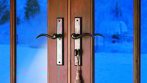 A set of Rocky Mountain Hardware multi-point door handles on a wooden patio door