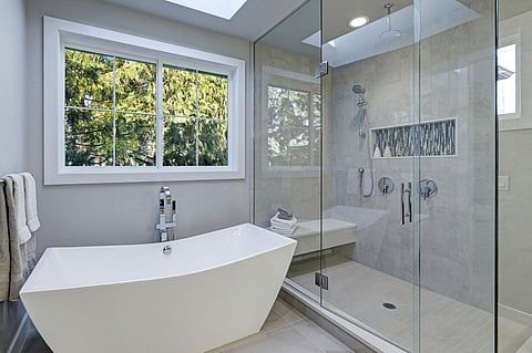 A modern, spa-inspired bathroom remodel featuring a large glass shower
