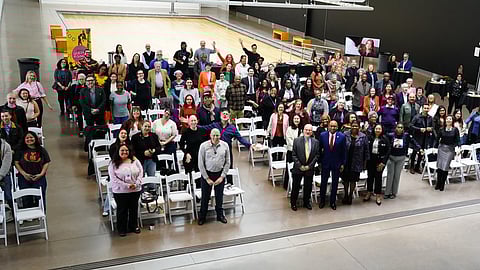 Large group of people posing inside event space at Queens Rising launch in New York