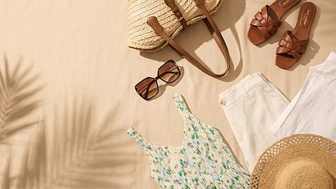 Flat lay of Los Angeles travel outfit with dress, sandals, tote and sunglasses