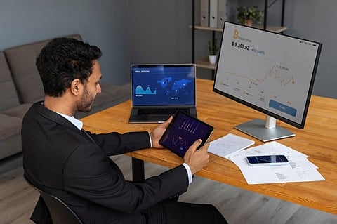 A business person analyzing finance graphs on a laptop