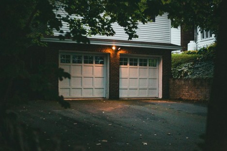 A two-car garage attached to a residential home at night.