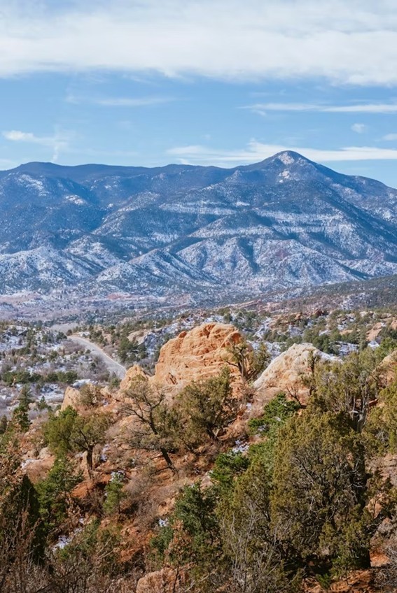 A scenic view of the Garden of the Gods park with Pikes Peak in the background.