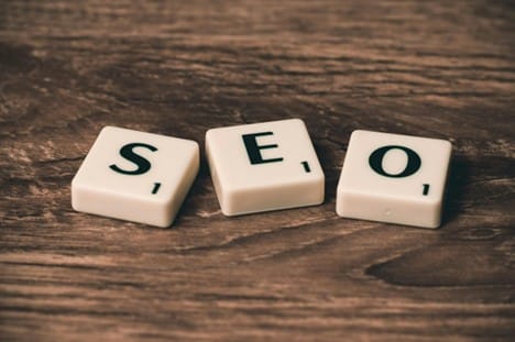 Scrabble letter tiles arranged to spell the acronym "SEO"