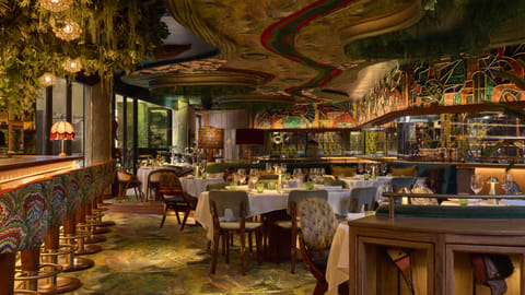 Amazónico Miami dining room with lush decor and vibrant ceiling design