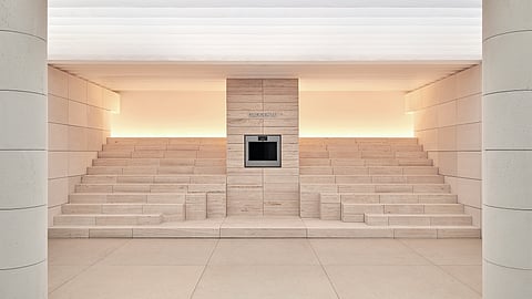 Symmetrical stone staircase with built-in oven and soft ambient lighting