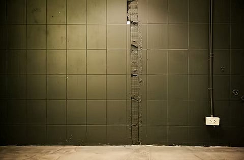 wall features a vertical strip of damaged or broken tiles