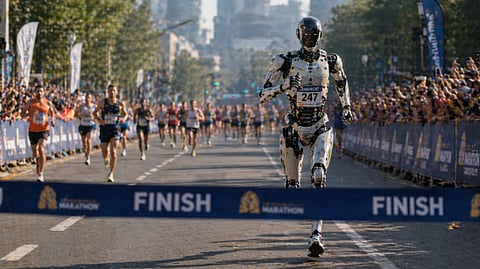 Humanoid robot crossing marathon finish line ahead of human runners
