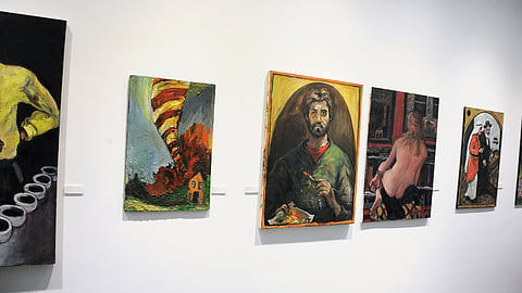 Gallery wall displaying multiple Chuck Connelly paintings including portrait and figurative works