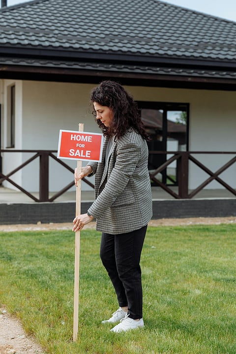 a red and white real estate "For Sale" lawn sign