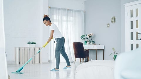 a person cleaning a bright, modern living room floor