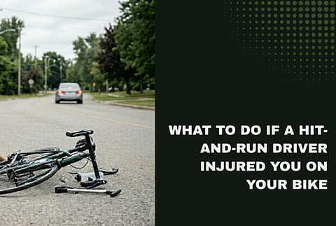 a green bicycle lying on the asphalt pavement