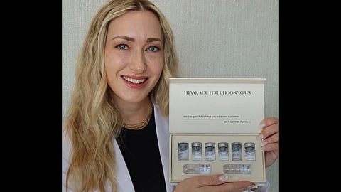 Woman holding an at-home microneedling skincare kit