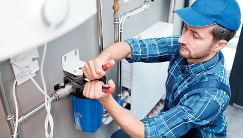 a plumbing professional servicing a water filtration system