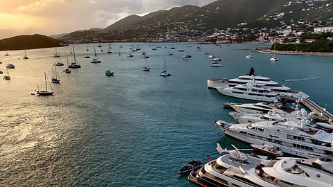 Luxury yachts anchored in a Caribbean marina during sunset