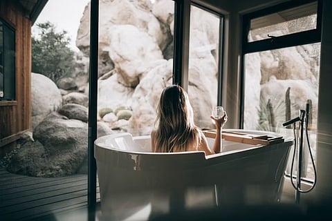 a contemporary white freestanding bathtub positioned near large windows offering a scenic view