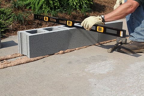 a person building a concrete block wall