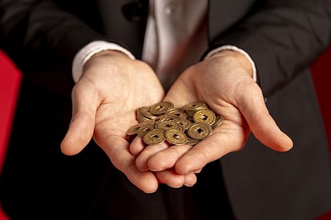 man holding gold coins