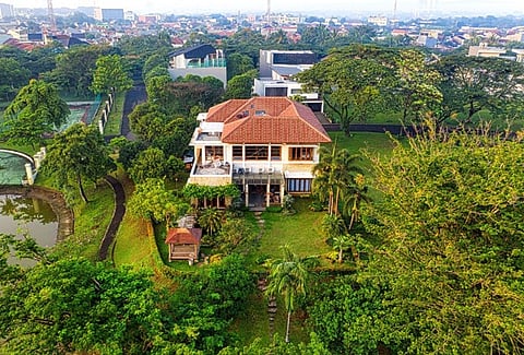an aerial view of a luxurious mansion surrounded by lush trees