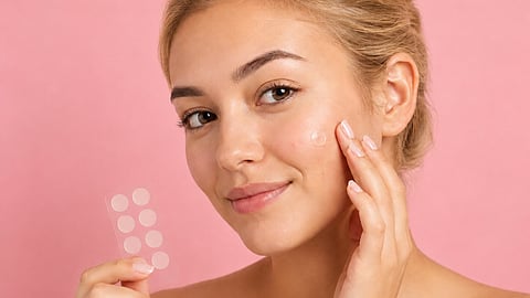 a person demonstrating the application of a small, clear acne patch