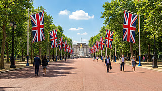Union Jack flags line The Mall leading to Buckingham Palace in London.